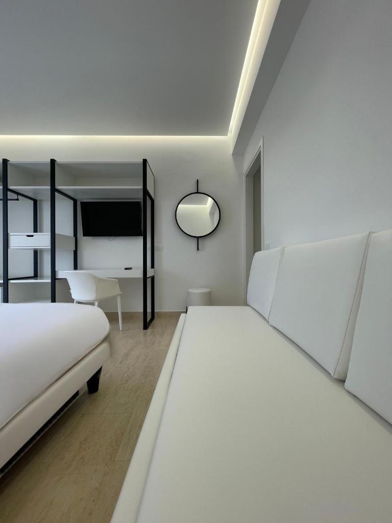 - une chambre blanche avec 2 lits et un bureau dans l'établissement Hotel Egitarso Sul Mare, à San Vito Lo Capo