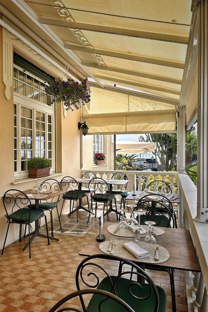 un restaurant avec des tables et des chaises sur une terrasse dans l'établissement Hotel Villa Igea, à Alassio