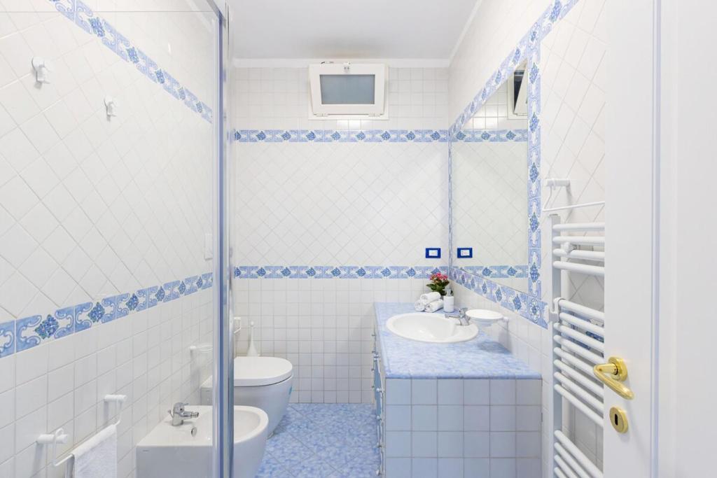une salle de bain bleue et blanche avec des toilettes et un lavabo dans l'établissement Villa La Scala, à Massa Lubrense