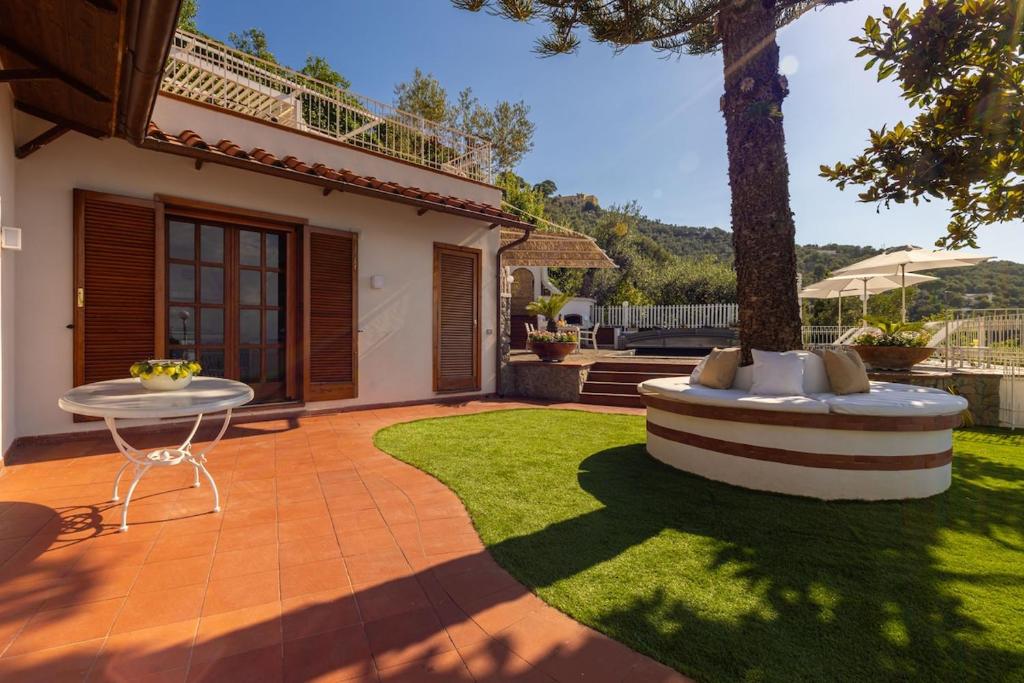 un jardin avec un banc et une table dans la pelouse dans l'établissement Villa La Scala, à Massa Lubrense