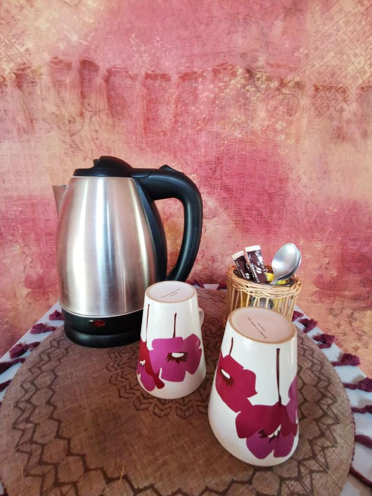 une bouilloire et deux tasses sur une table dans l'établissement Yourte Namaste Homestay, à Saint-Pargoire