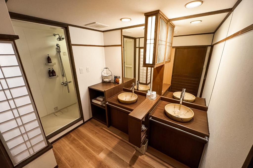 une salle de bain avec deux lavabos et une douche dans l'établissement Aburaya Tousen, à Yamanouchi