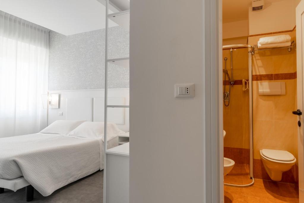 - une chambre avec un lit, une douche et des toilettes dans l'établissement Hotel Majestic, à Milano Marittima