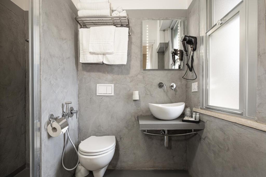 une salle de bain avec toilettes, lavabo et miroir dans l'établissement BI Hotel, à Bellaria-Igea Marina