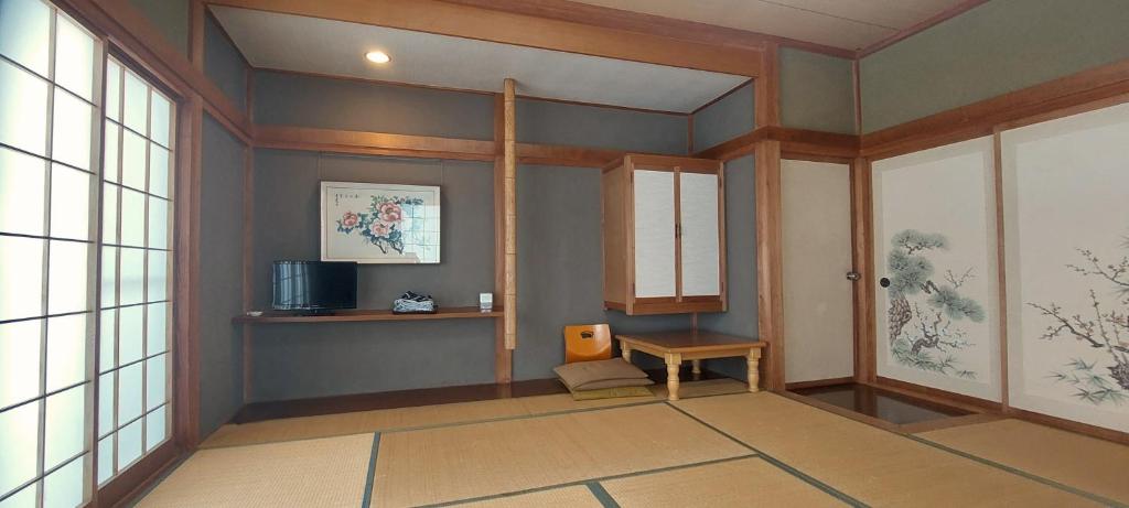 - un couloir avec une chambre dotée d'une table et de fenêtres dans l'établissement Masugataya Ryokan, à Tako
