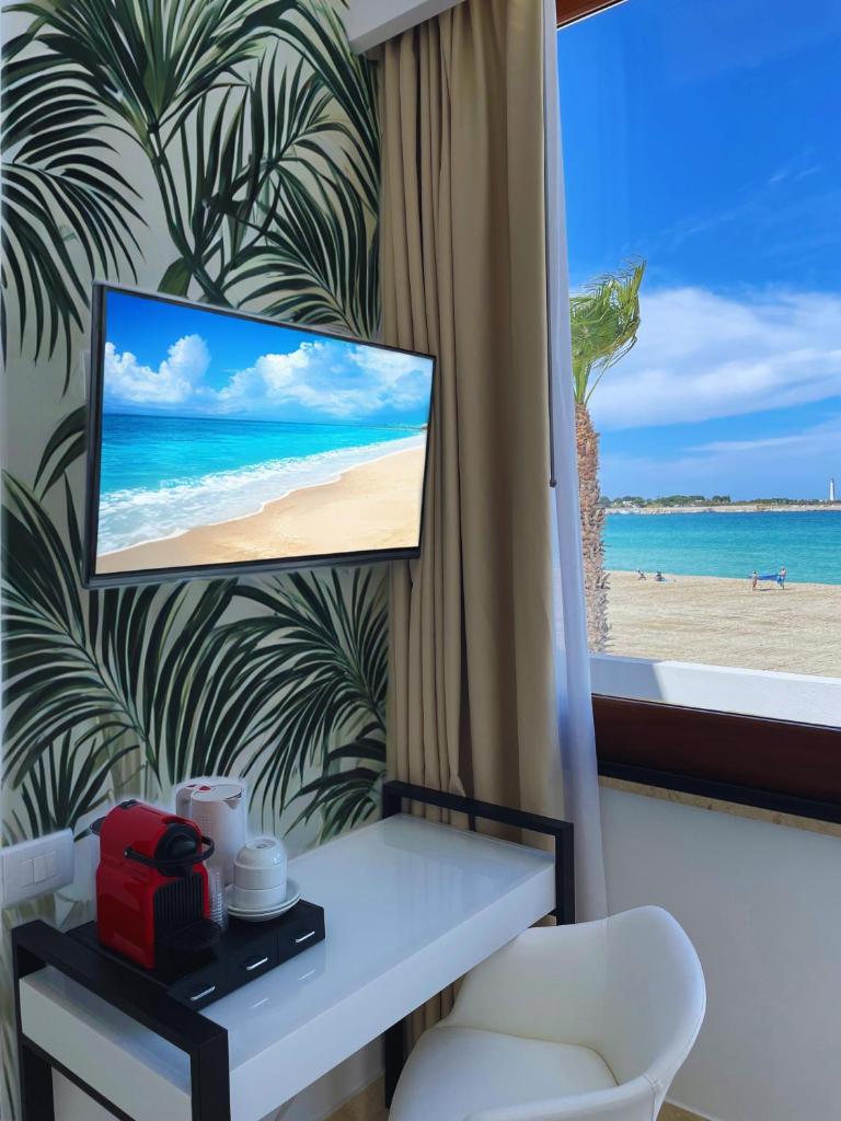 une chambre avec vue sur la plage et une télévision dans l'établissement Hotel Egitarso Sul Mare, à San Vito Lo Capo