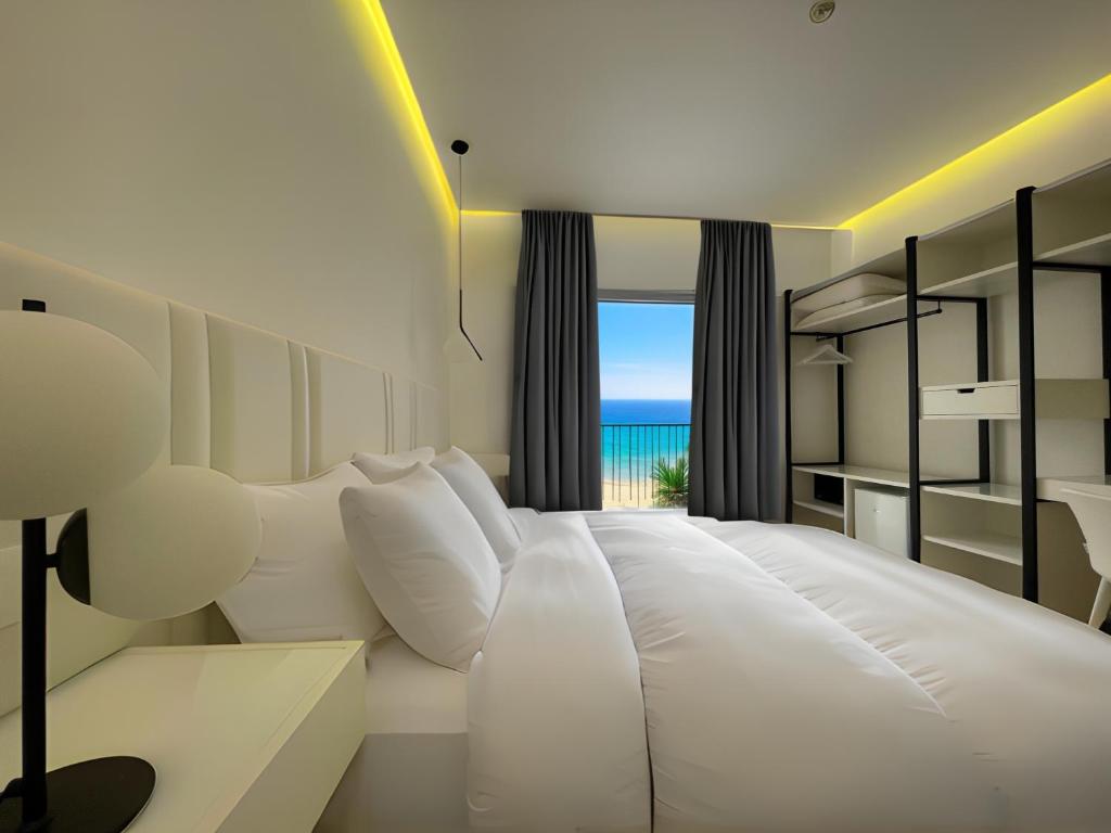 une chambre avec un lit blanc avec vue sur l'océan dans l'établissement Hotel Egitarso Sul Mare, à San Vito Lo Capo