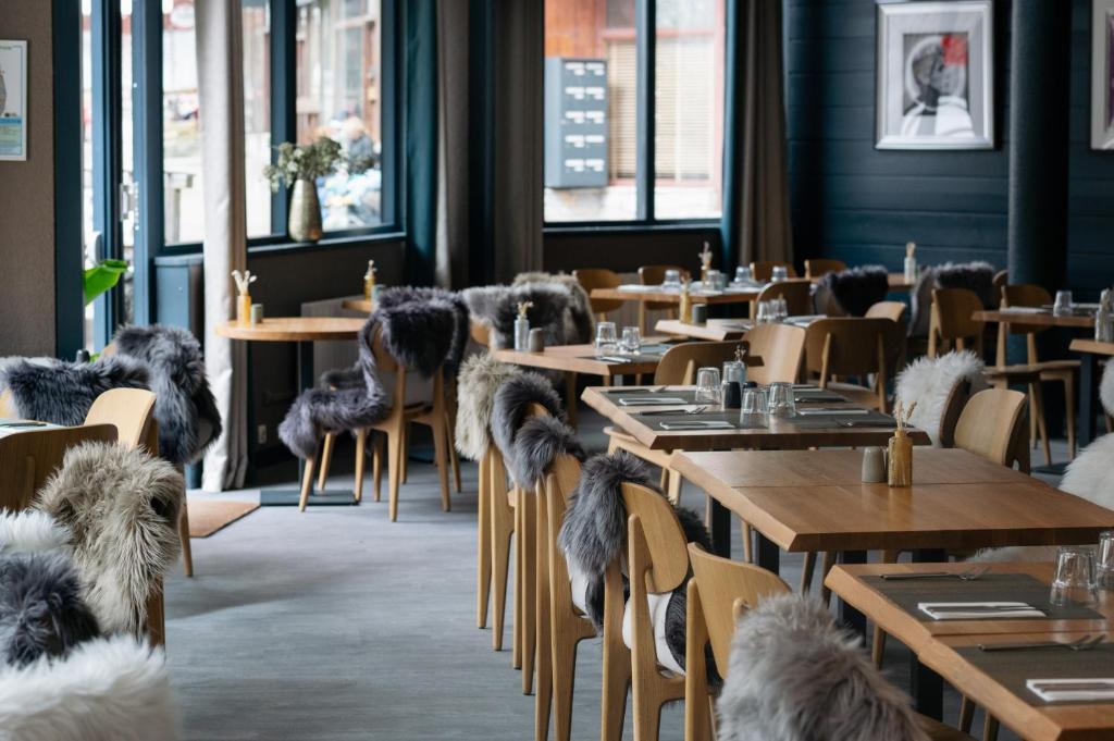 un restaurant avec des tables et des chaises avec des chiens dessus dans l'établissement Hôtel Le Montana, à La Tania 37 autres photos