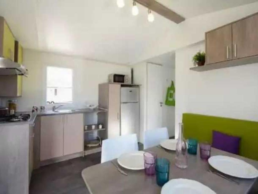 une cuisine avec une table et des chaises dans une pièce dans l'établissement Camping 4 étoiles - Piscine - eed0fe, à Thégra