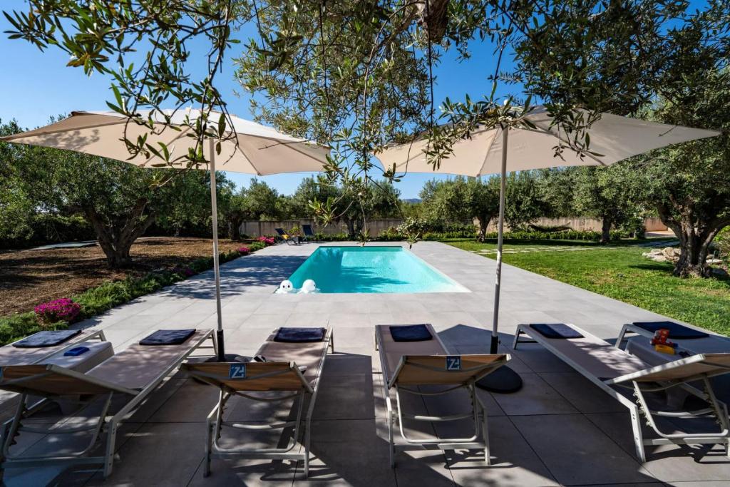 une piscine avec des chaises et un parasol dans l'établissement Villa Virginia - Relax and Private Pool, à Paceco