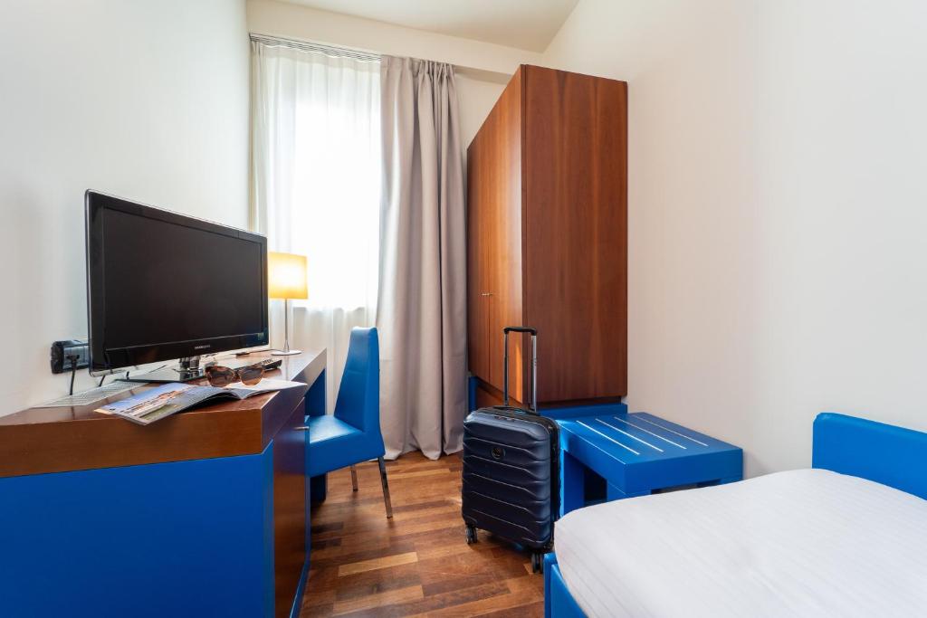 une chambre d'hôtel avec un lit et un bureau avec une télévision dans l'établissement Hotel Balance, à Milano Marittima