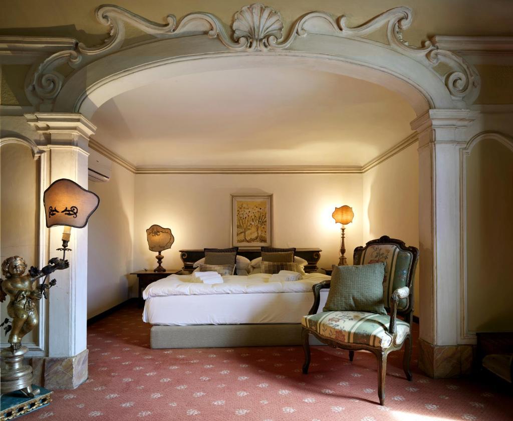 une chambre avec un lit blanc et une chaise dans l'établissement San Niccolò a Olmeto, Torre e Chiesa del XIII secolo, à Rignano sullʼArno 75 autres photos