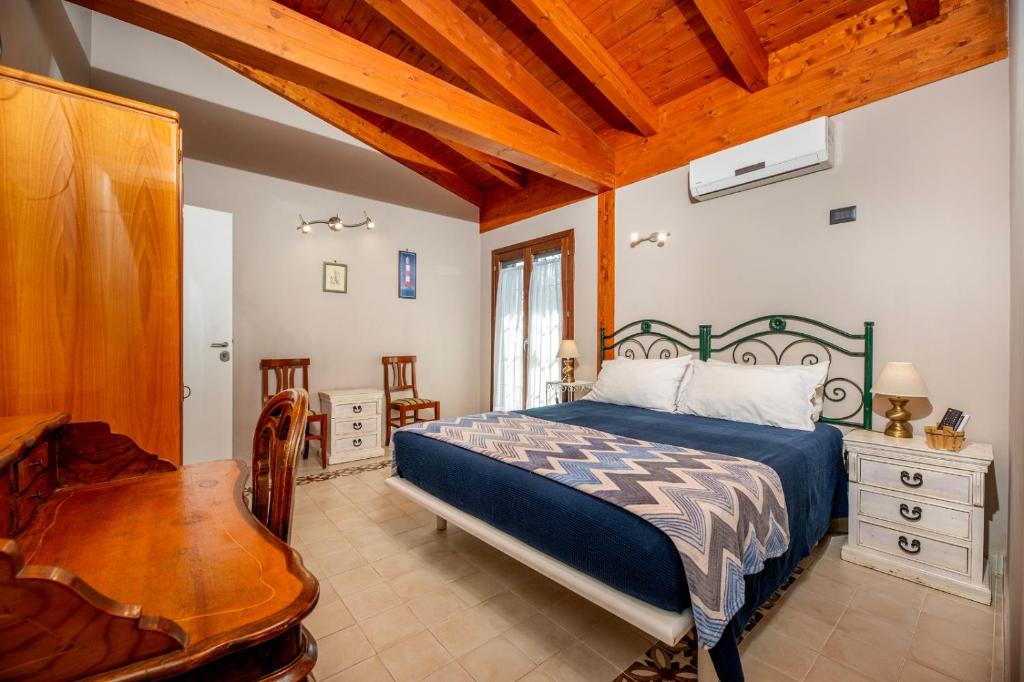 une chambre avec un lit et un plafond en bois dans l'établissement La collina delle fonti, à Aprilia