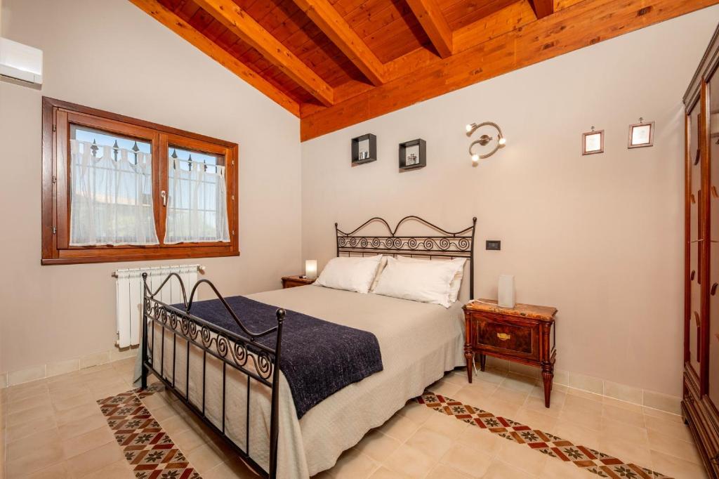 une chambre avec un lit et un plafond en bois dans l'établissement La collina delle fonti, à Aprilia