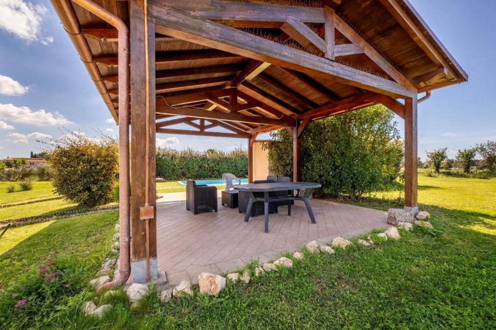 - un pavillon avec une table et des chaises dans un champ dans l'établissement La collina delle fonti, à Aprilia