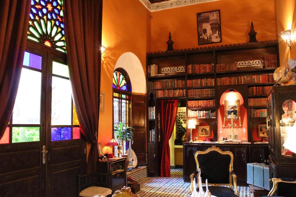 une bibliothèque avec des étagères remplies de livres dans l'établissement Riad Le Calife, à Fès