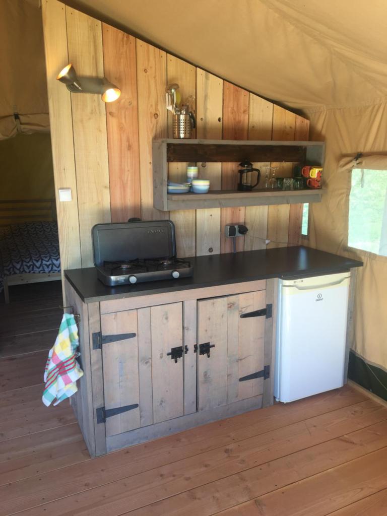 - une cuisine avec un comptoir et une télévision dans l'établissement SafariLodge 6 persoons, à Chaumont