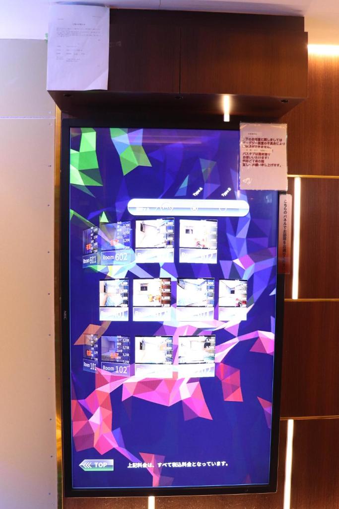 un réfrigérateur avec un écran coloré dans une pièce dans l'établissement Ikebukuro Montana, à Tokyo