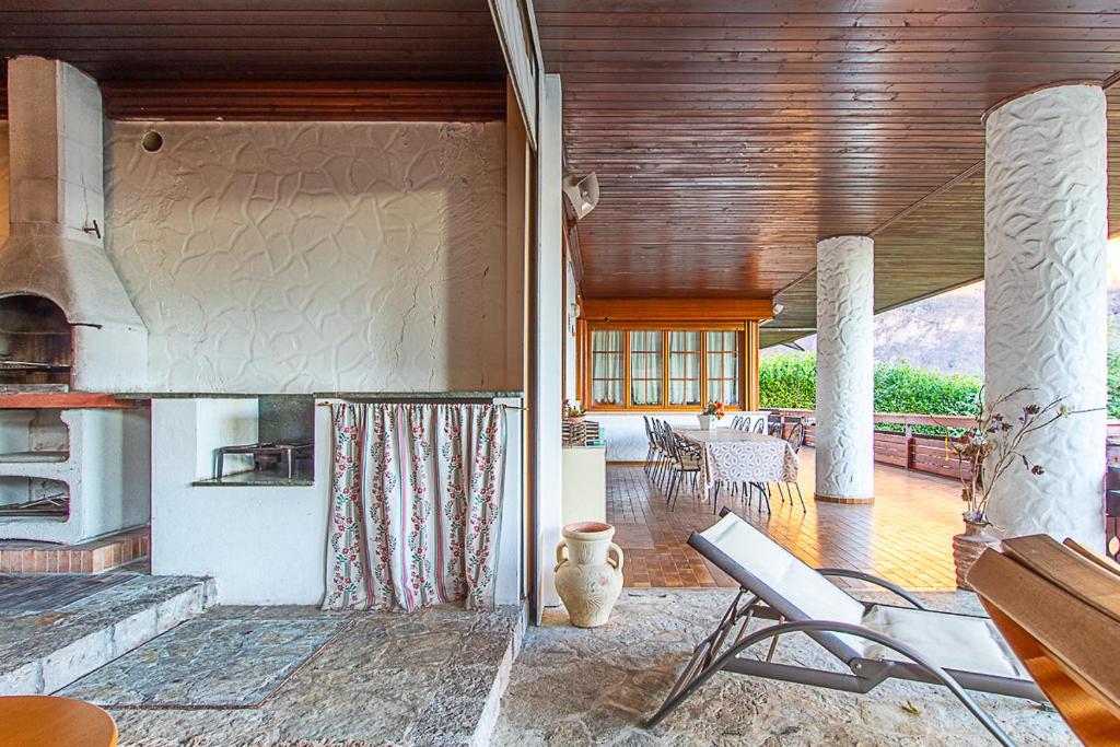 - un salon avec une cheminée, une table et des chaises dans l'établissement Villa Mazzucco, à Ponte nellʼAlpi