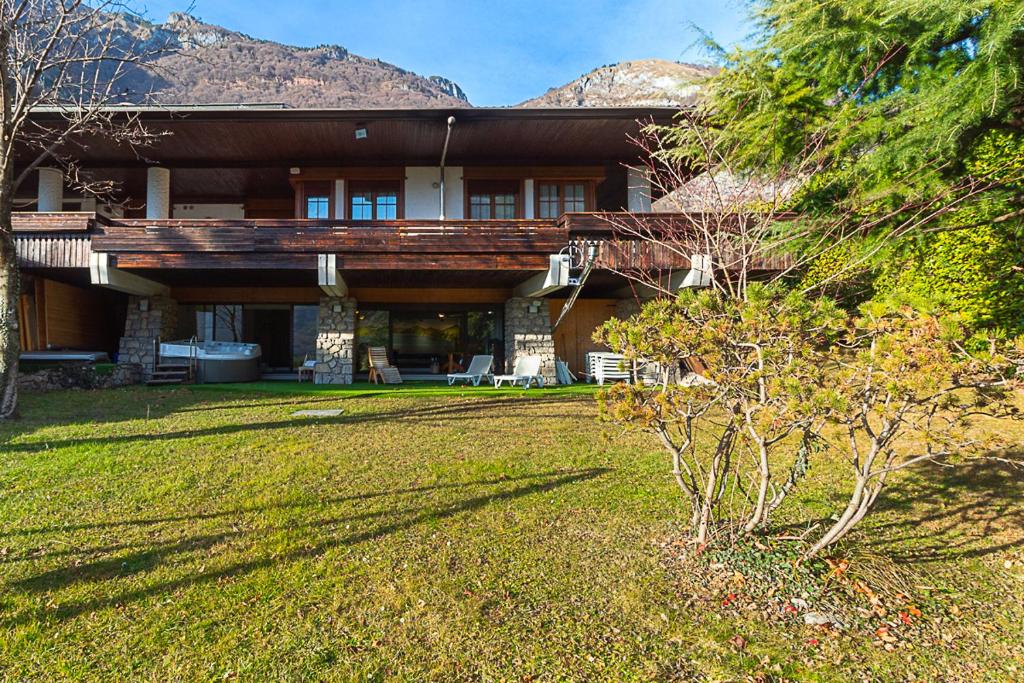 une grande maison avec une montagne en arrière-plan dans l'établissement Villa Mazzucco, à Ponte nellʼAlpi