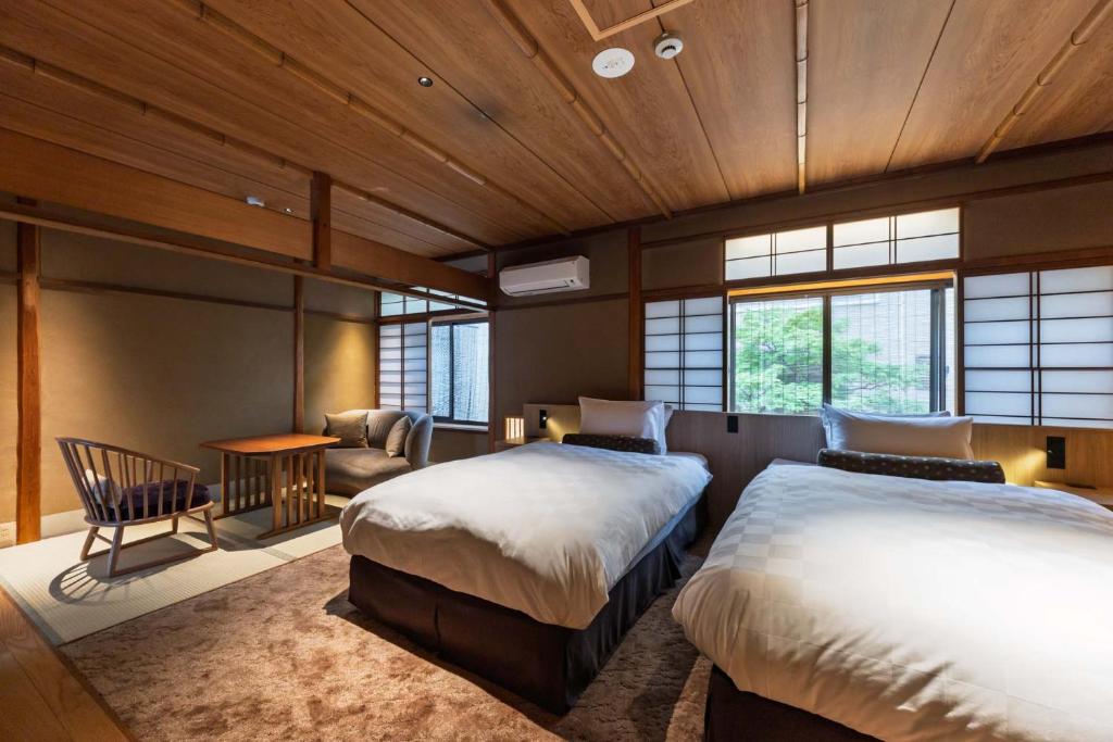 - une chambre avec deux lits, une chaise et un canapé dans l'établissement Kyoto Ryokan SAKANOUE, à Kyoto