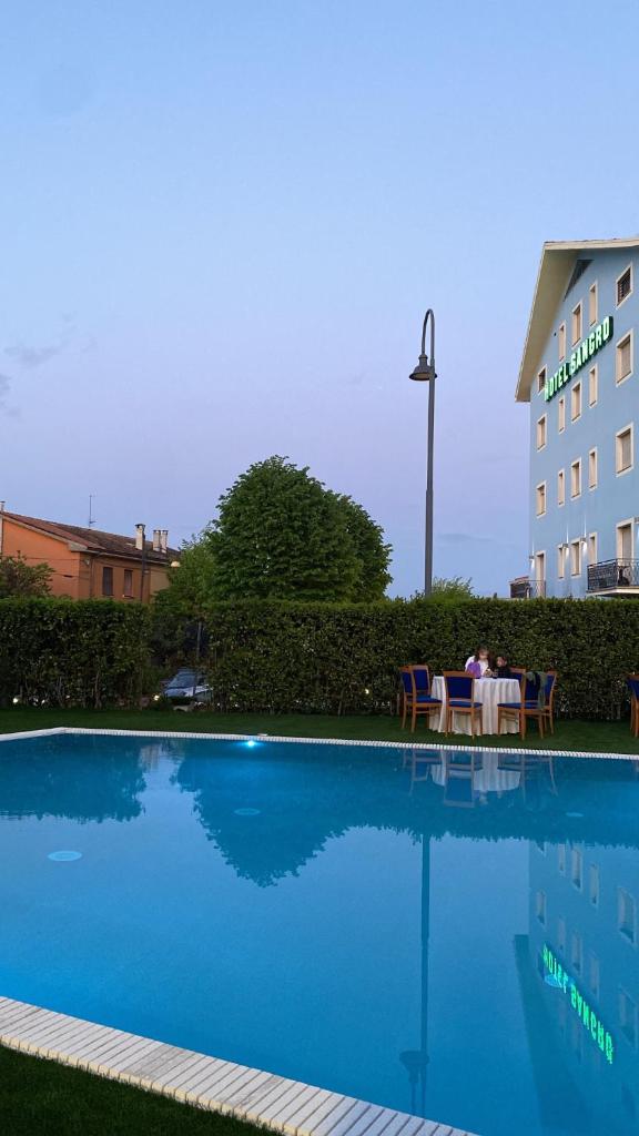 une personne assise à une table à côté d'une piscine dans l'établissement Hotel Sangro, à Mozzagrogna