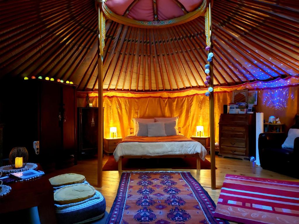 une chambre avec un lit dans une yourte dans l'établissement La Yourte aux Bambous en Cévennes, à Saint-André-de-Majencoules