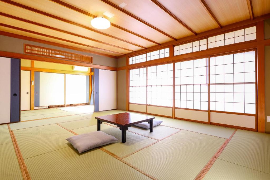 une pièce avec une table dans une pièce avec des fenêtres dans l'établissement Ooedo Onsen Monogatari Premium Yamashitaya, à Kaga