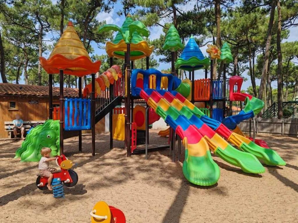 une aire de jeux avec toboggan coloré et structure de jeu dans l'établissement Camping 3 étoiles - Parc aquatique - ccaff0b, à Saint-Hilaire-de-Riez