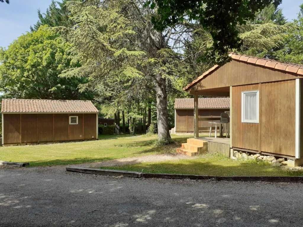 une maison avec un arbre à côté d'une rue dans l'établissement Camping 3 étoiles - Piscine - ccaideg, à Reyrevignes