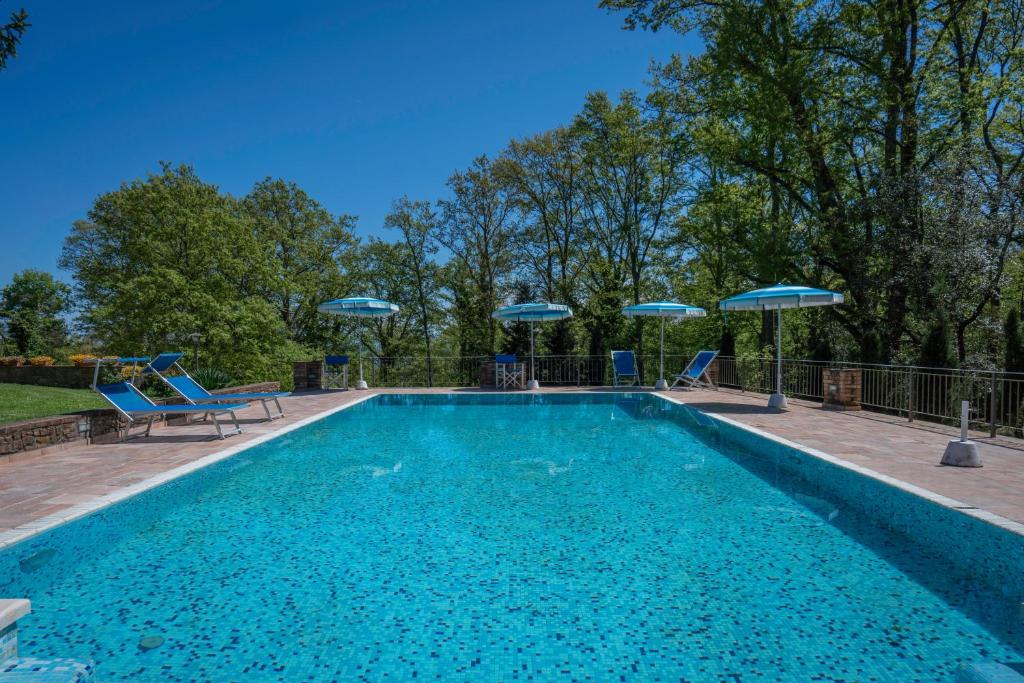 une piscine avec des chaises bleues et des parasols dans l'établissement Grace Home, Pool, Wifi, Gambassi Terme, à Gambassi Terme