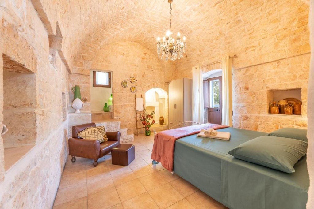 une chambre avec un grand lit dans un mur de briques dans l'établissement Villa Narkive, à Carovigno