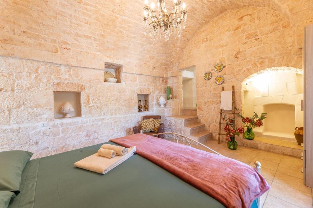 une chambre avec un grand lit dans un mur de pierre dans l'établissement Villa Narkive, à Carovigno