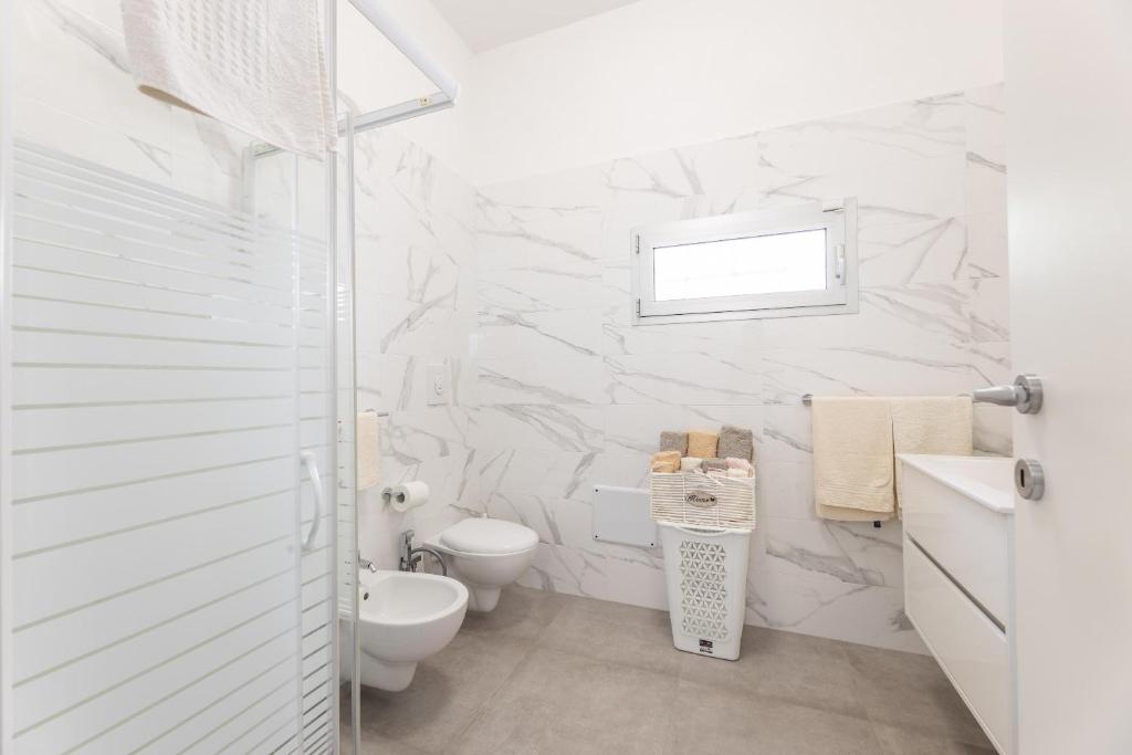 une salle de bain blanche avec toilettes et lavabo dans l'établissement Villa Narkive, à Carovigno 22 autres photos