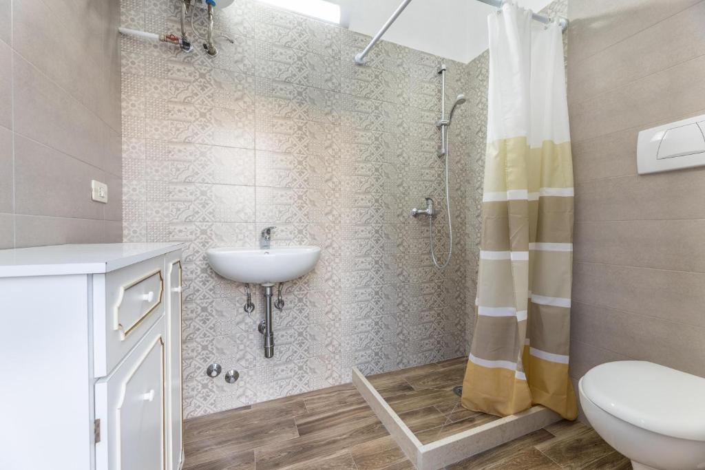une salle de bain avec un lavabo, des toilettes et une douche dans l'établissement Villa Narkive, à Carovigno