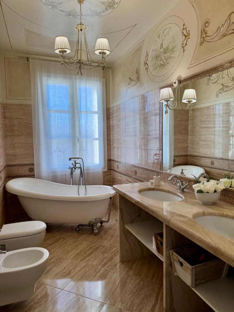 La grande salle de bains est pourvue d'une baignoire et de deux lavabos. dans l'établissement Villa Donatella, à Alessano