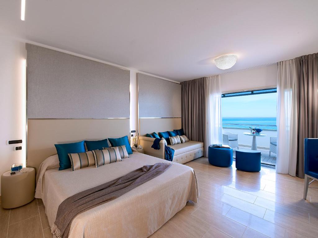 une chambre avec un grand lit et une vue sur l'océan dans l'établissement Hotel I Ginepri, à Marina di Castagneto Carducci 73 autres photos