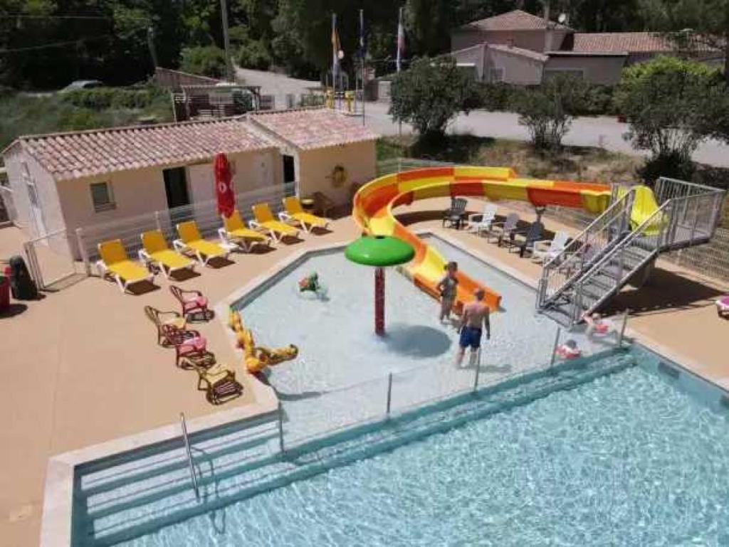 une piscine avec un parc aquatique avec un toboggan et des chaises dans l'établissement Camping 3 étoiles - Parc aquatique - eecfea, à Saint-Maime