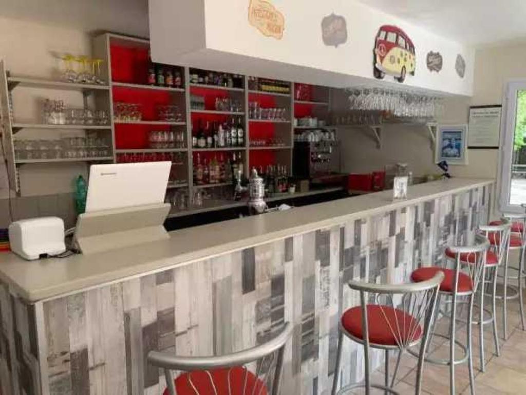 - un bar avec tabourets de bar rouge dans un restaurant dans l'établissement Camping 3 étoiles - Parc aquatique - eecfea, à Saint-Maime