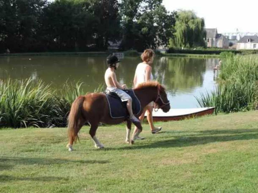 - deux personnes à cheval à côté d'un bateau dans l'établissement Camping 4 étoiles - Piscine - eed0aa, à Estipouy