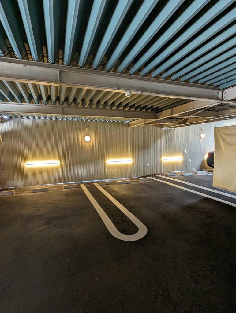 un parking vide avec un mur métallique dans l'établissement ホテル カサブランカ 尼崎, à Amagasaki