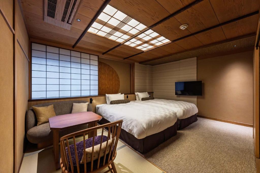 une chambre avec un grand lit et un canapé dans l'établissement Kyoto Ryokan SAKANOUE, à Kyoto