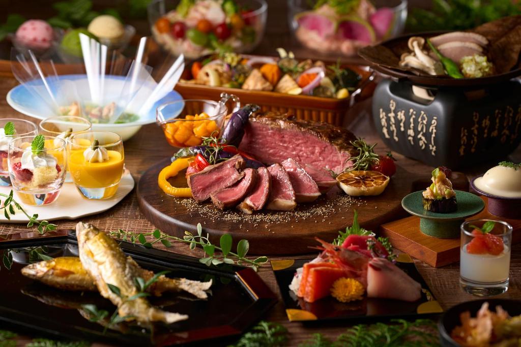 une table avec une plaque de viande et d'autres denrées alimentaires dans l'établissement TAOYA Gero, à Gero 12 autres photos
