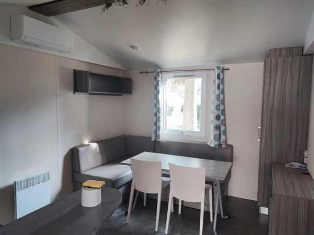 un salon avec une table, des chaises et un canapé dans l'établissement Camping 4 étoiles - Parc aquatique - eehhd0, à Saint-Cyprien