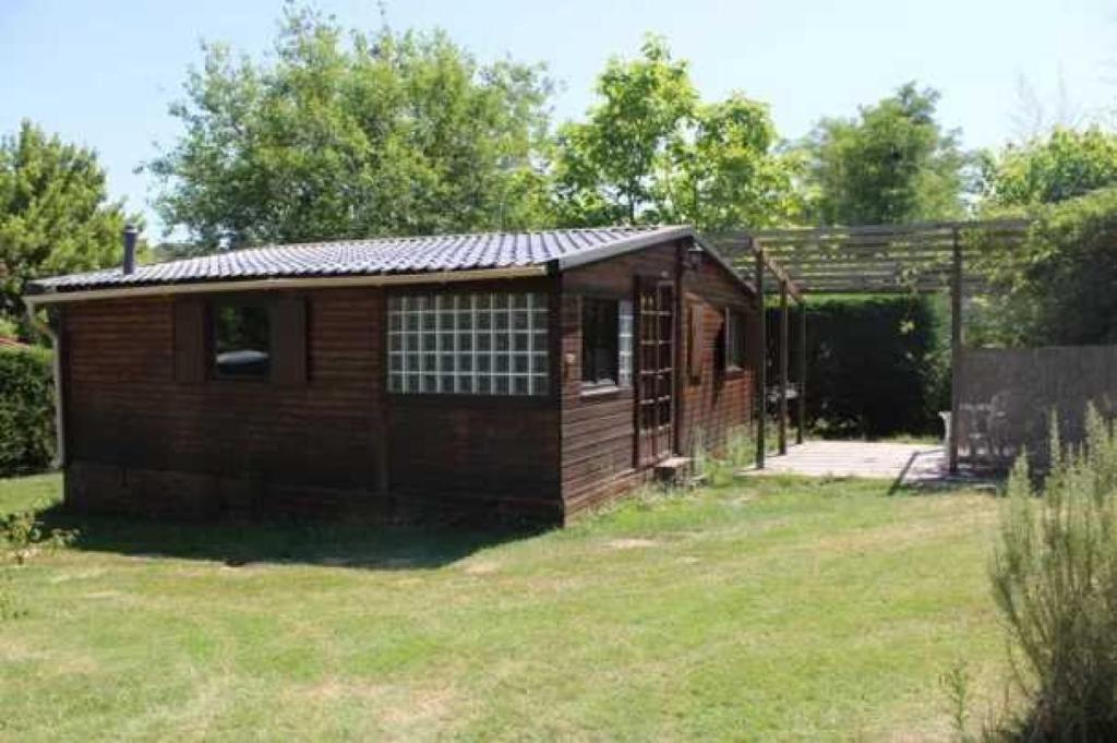 une petite cabane dans une cour avec un portail dans l'établissement Camping 3 étoiles - Piscine - eehgei, à Castelnau-Picampeau
