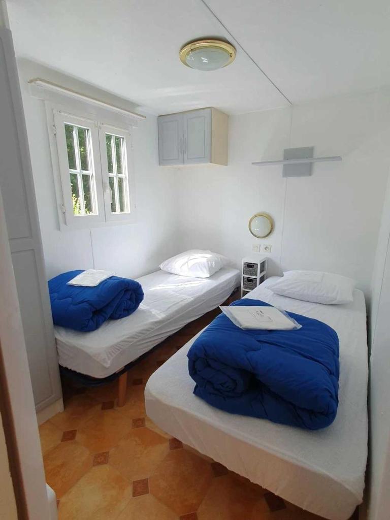 une chambre avec deux lits avec des draps bleus dedans dans l'établissement Camping 3 étoiles - Piscine - eeicbh, à Le Change