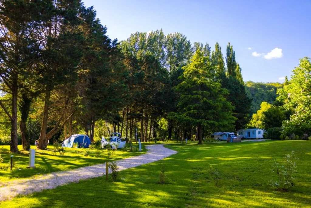 un camping avec des tentes dans un champ arboré dans l'établissement Camping 3 étoiles - Piscine - eeicbh, à Le Change