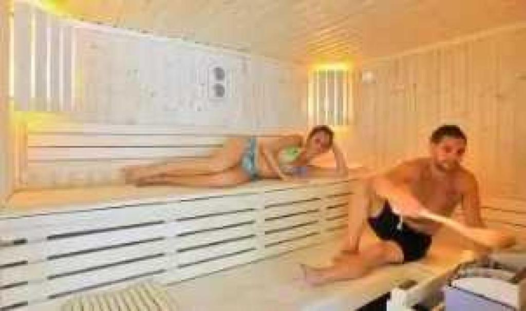 un homme et une femme assis dans une baignoire dans l'établissement Chalet 4 étoiles - Piscine - ef0ccc, à Albi