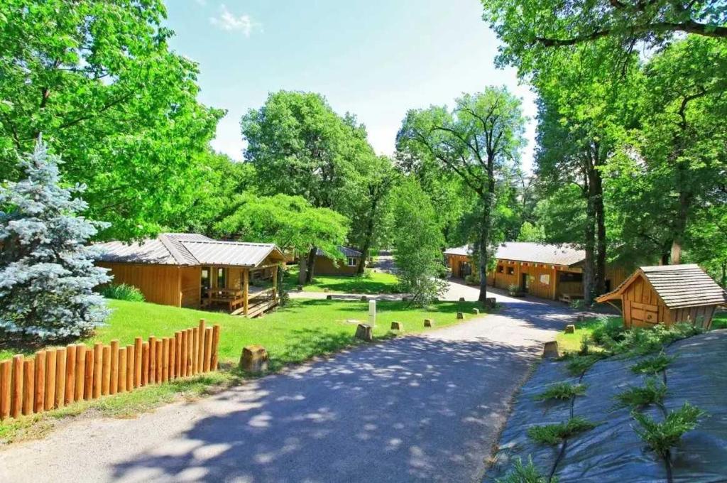 une route menant à un groupe de bâtiments en bois dans l'établissement Chalet 4 étoiles - Piscine - ef0ccc, à Albi