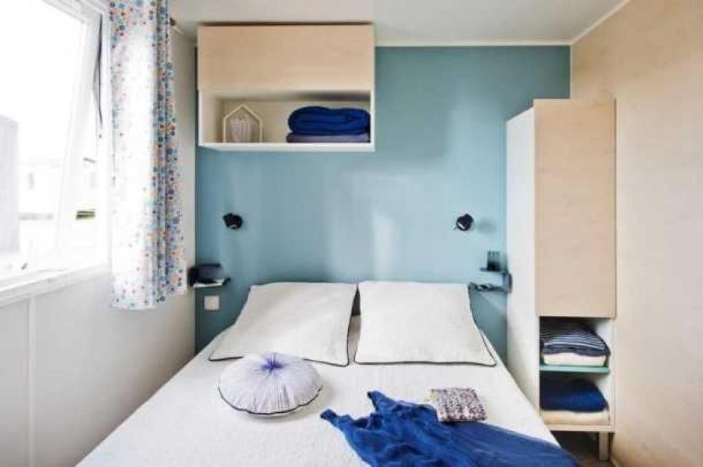 une chambre avec un lit avec un mur bleu dans l'établissement Camping 3 étoiles - Parc aquatique - eecehf, à Fréjus